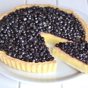 crostata con crema e mirtilli servita